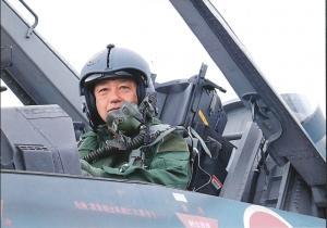 町長がヘルメットを被り戦闘機に座っている写真