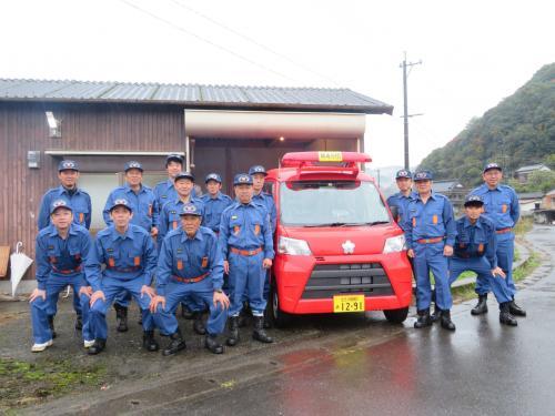 消防団第4分団東上消防車(赤い小型動力ポンプ付軽積載車) と団員の皆さんの写真