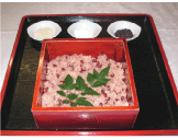 赤く四角い容器に入った赤飯の写真