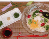 素麵の上に錦糸卵、キュウリ、オクラ、トマトなどの野菜が盛り付けられた冷やしそうめんの写真