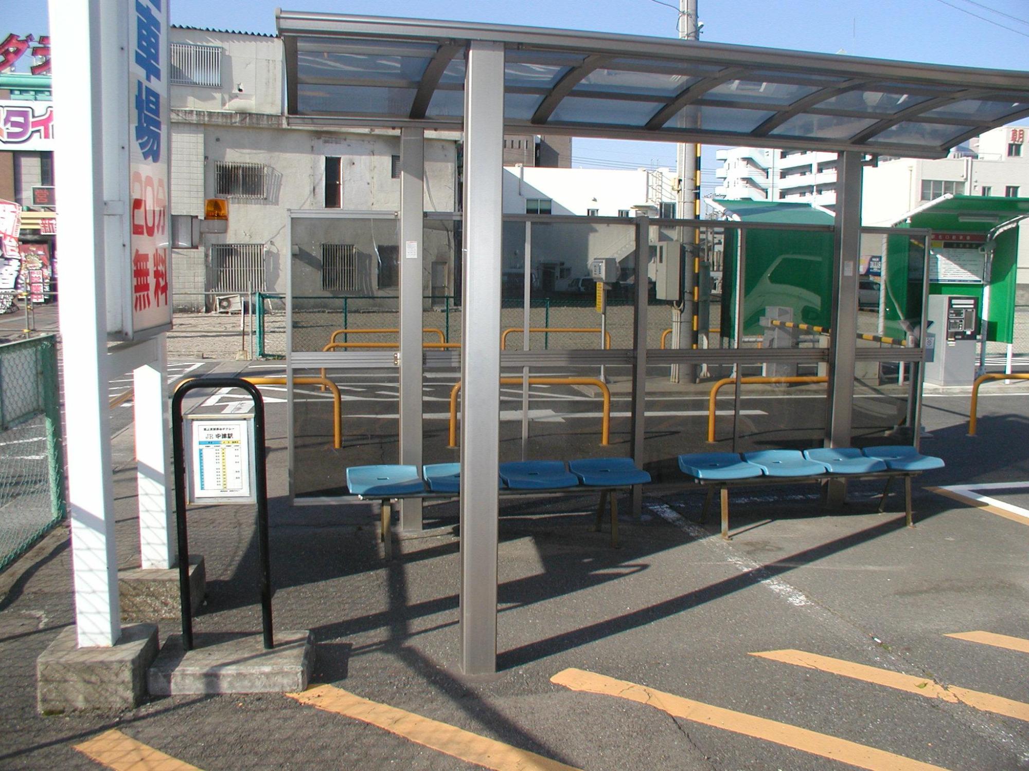 青いベンチと雨除けのある待合所の写真